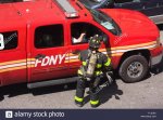 fdny-firefighter-in-full-turnout-gear-speaks-with-his-supervisor-in-F1JDEA.jpg